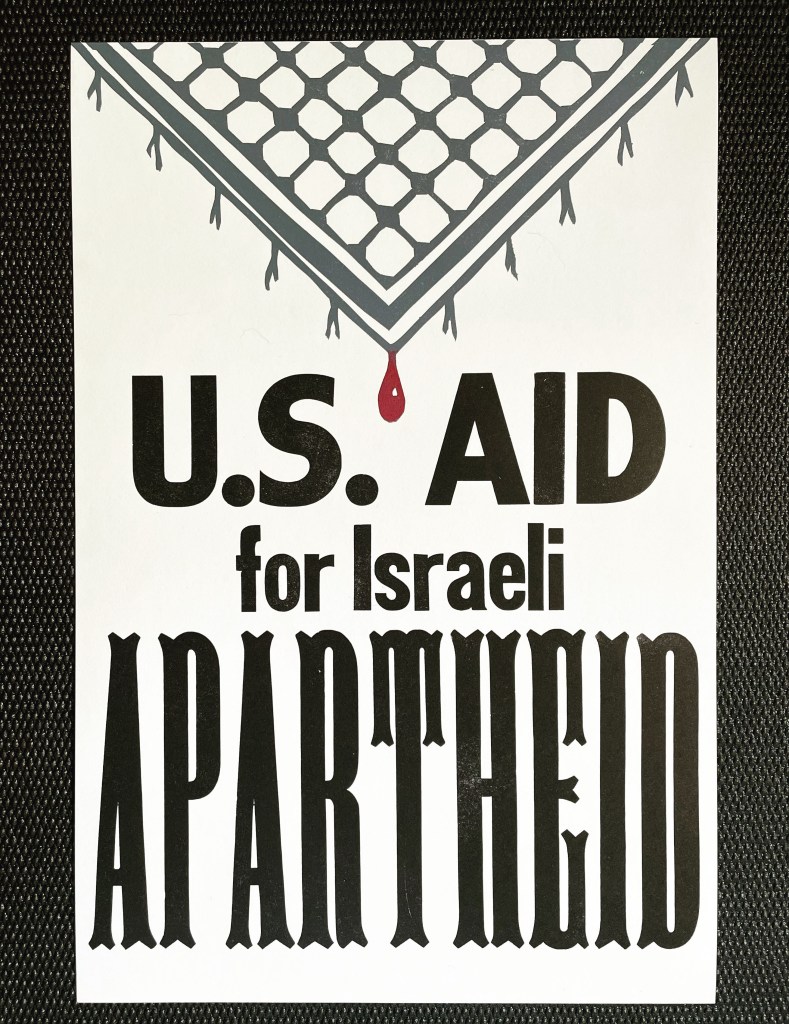 Khaffiya with blood drop; wood type says "US Aid for Israeli APARTHEID" below